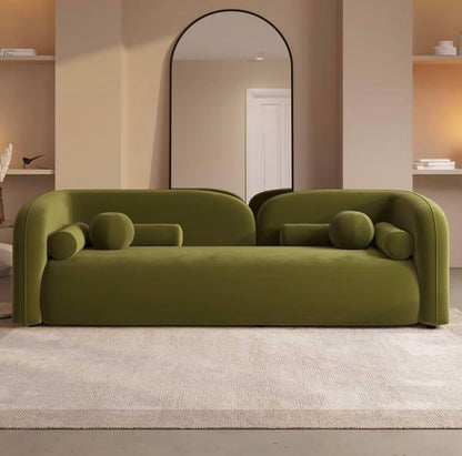 Modern green sofa in a room with a mirror and shelves.