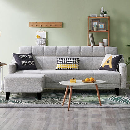 Gray sectional sofa with decorative pillows in a living room setting.