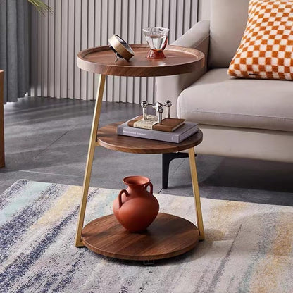 Wooden side table with gold legs in a living room setting
