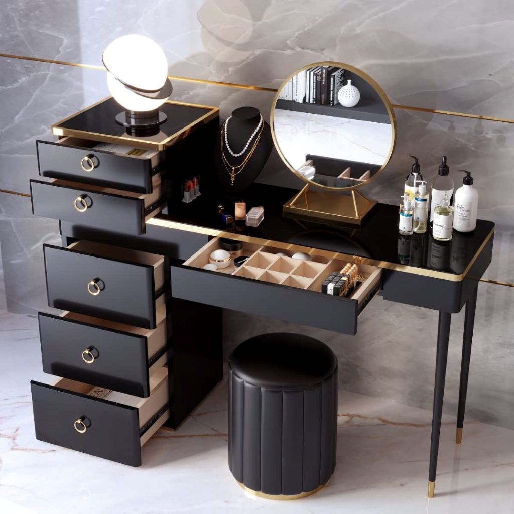Black vanity table with makeup items and mirror on a marble floor