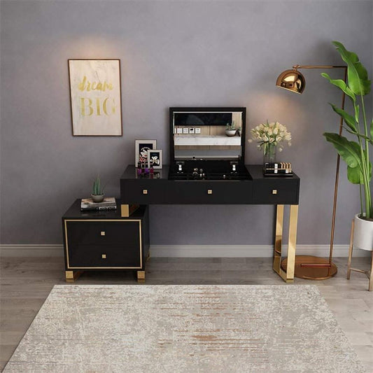 Modern black and gold vanity with mirror, lamp, and decor items in a room with gray walls and a plant.