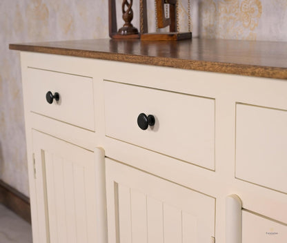Beige cabinet with black knobs against a patterned wall.