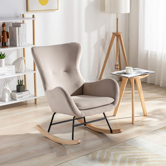 Beige rocking chair in a modern living room with a side table and decor items.