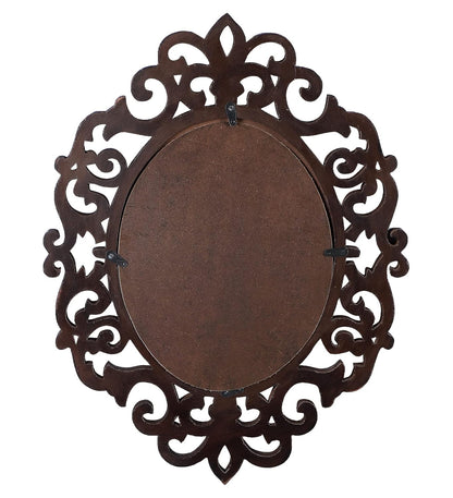 Decorative metal wall mirror with intricate filigree design on a white background