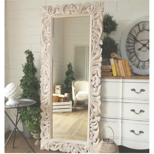 Decorative full-length mirror with intricate carvings in a room setting.