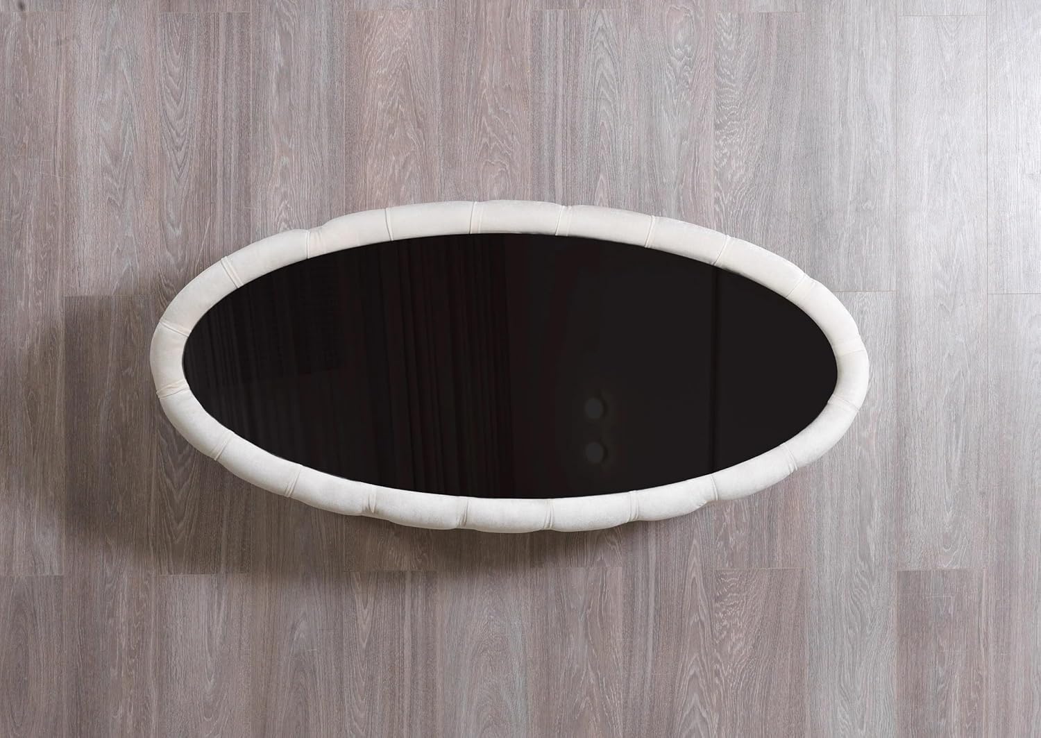 Round black object with white rim on a wooden surface