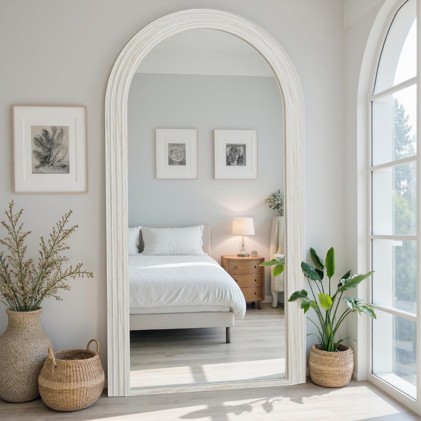 Large arched mirror in a bedroom with plants and decor