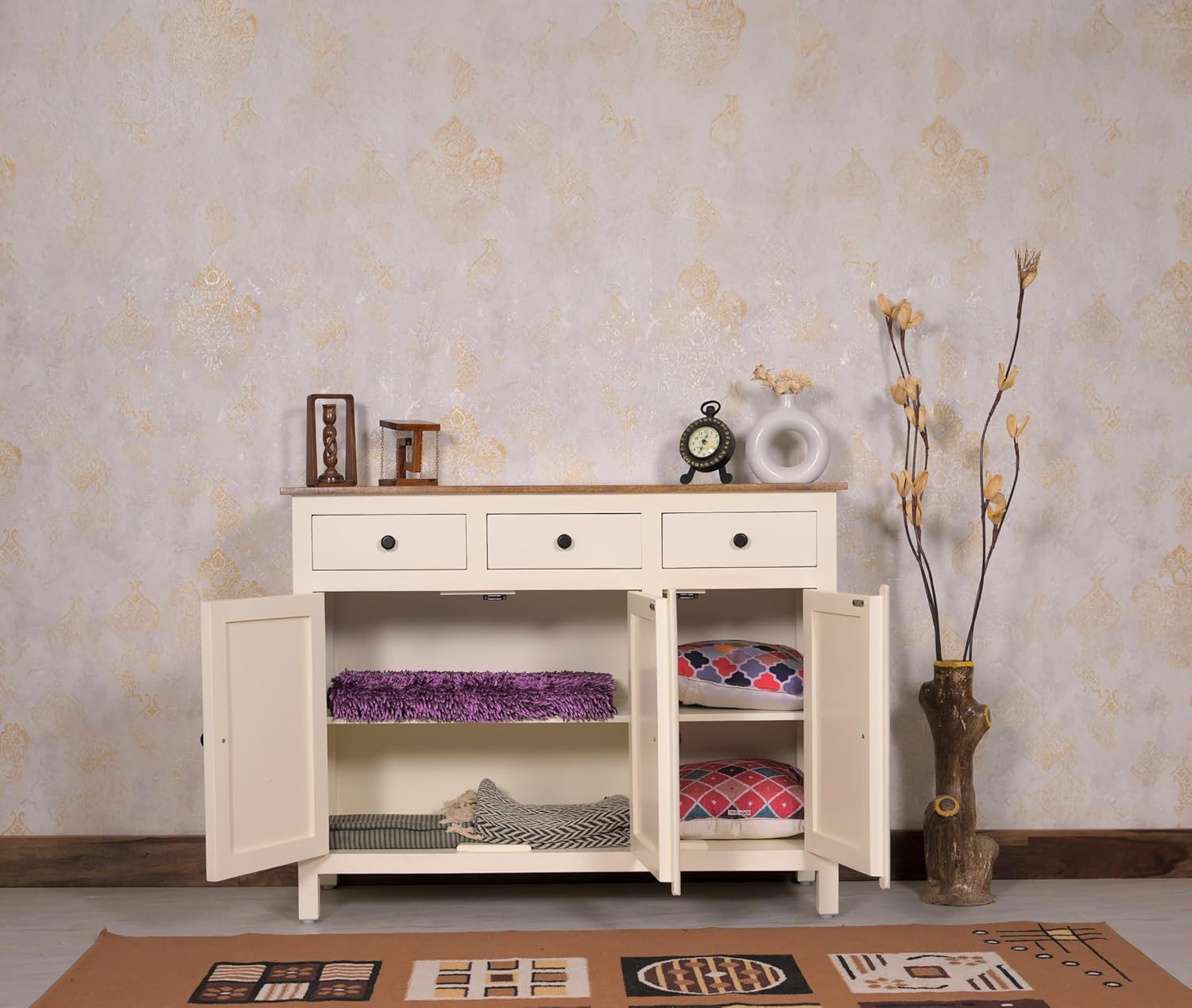 White wooden sideboard with open doors displaying various items against a patterned wall.