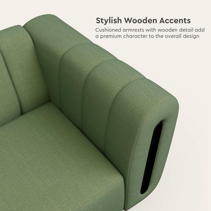 Green sofa with cushioned armrests and wooden accents on a light background