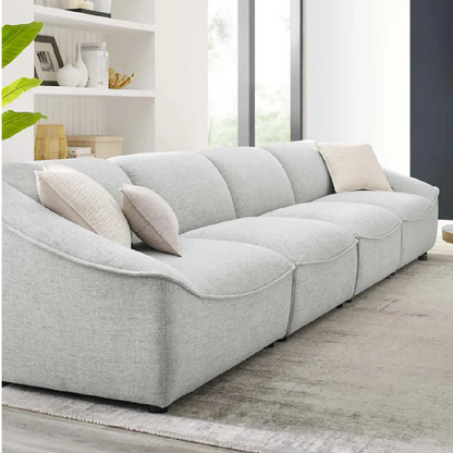 Gray sectional sofa in a living room setting with cushions.