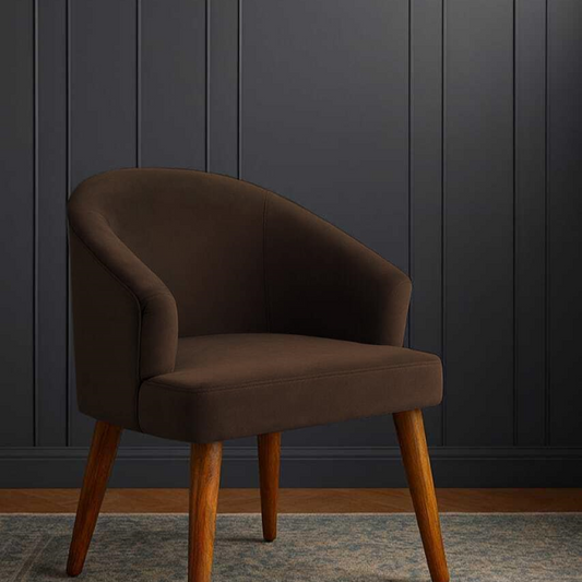 Brown armchair with wooden legs against a dark paneled wall.