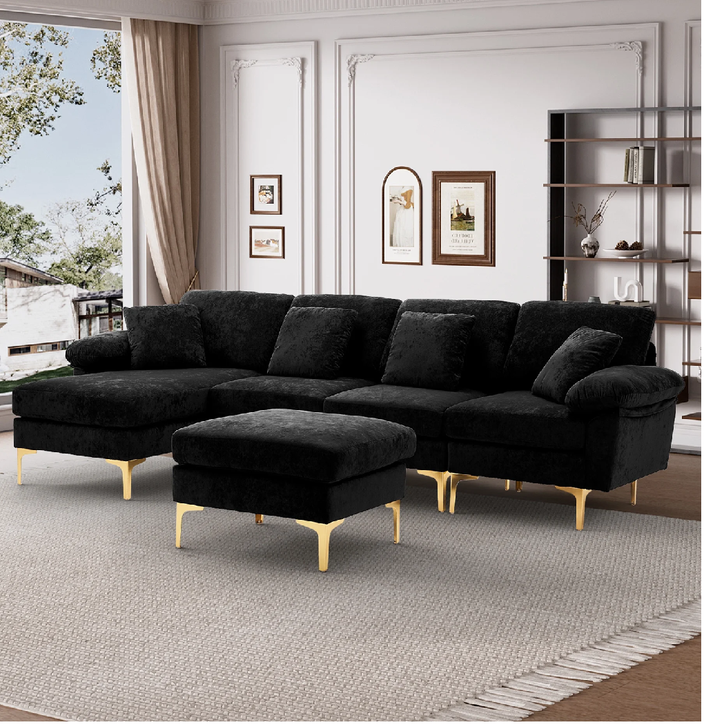 Black sectional sofa with gold legs in a living room setting