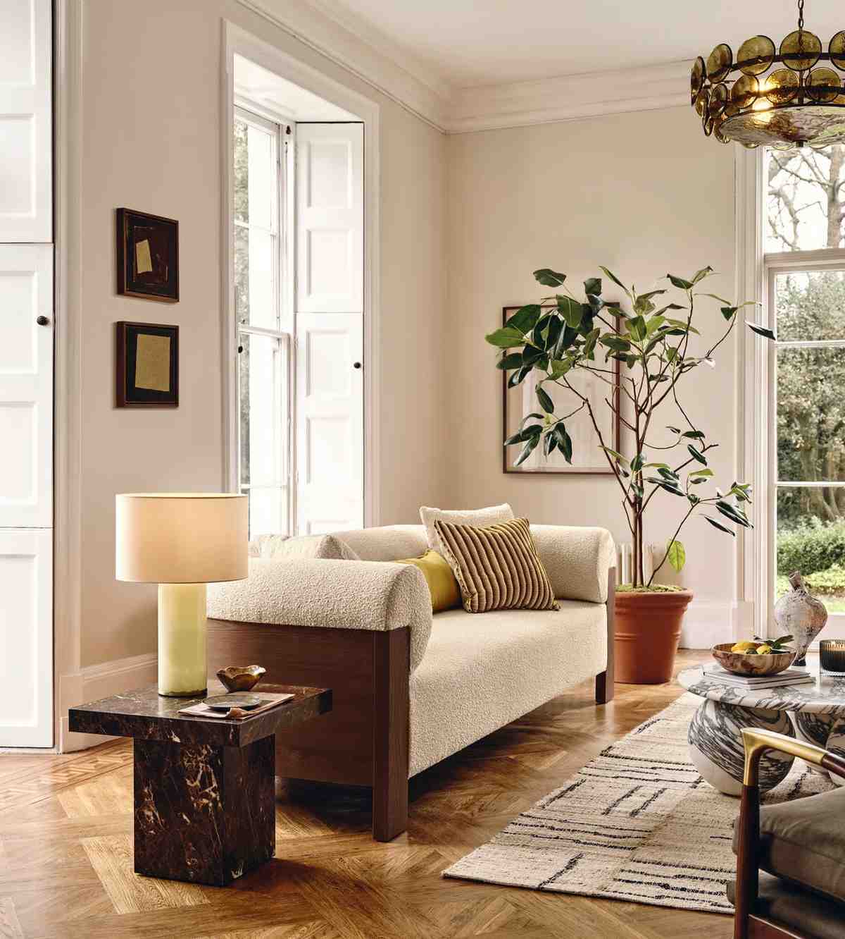 Living room with a beige sofa, marble coffee table, and decorative elements.
