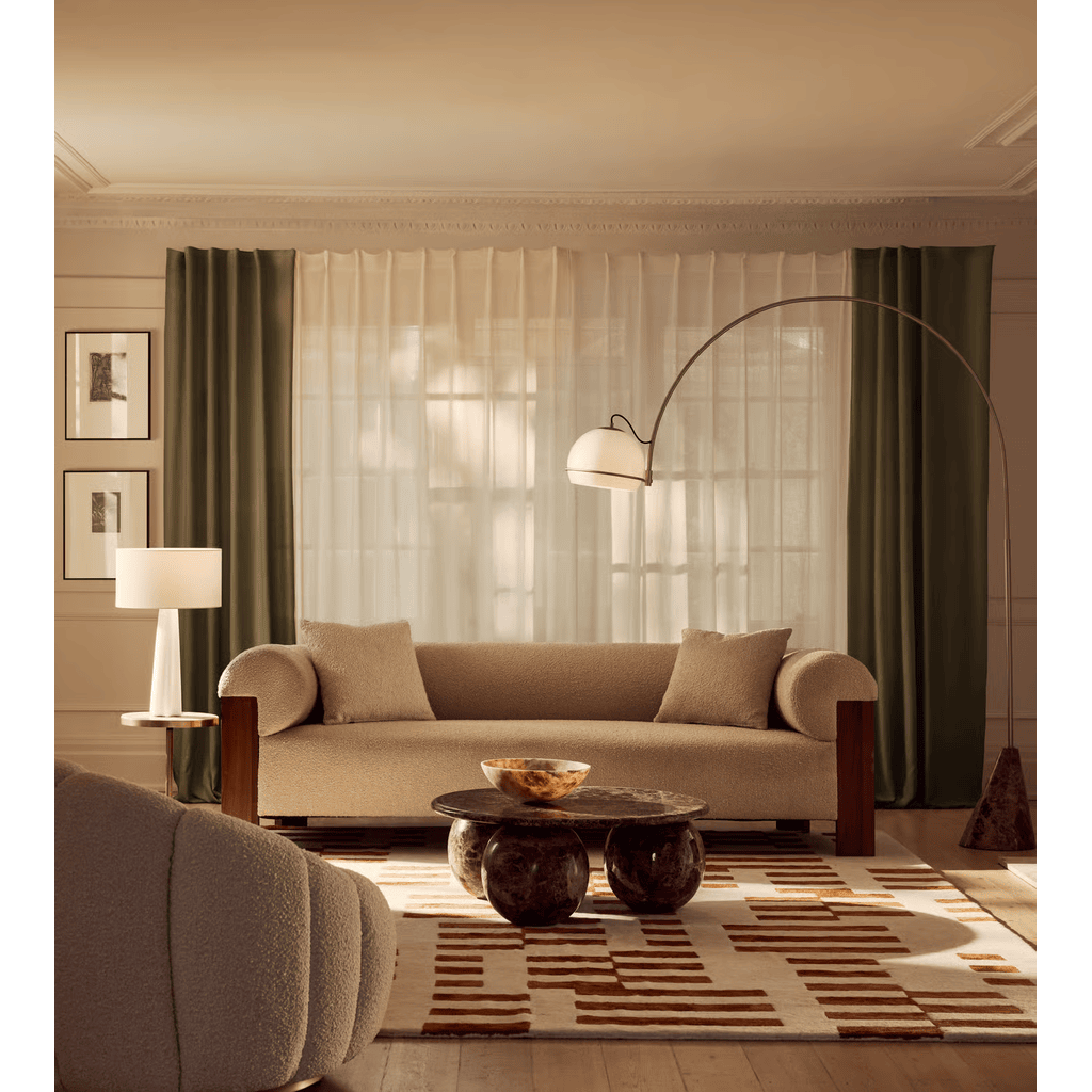 Modern living room with beige sofa, coffee table, and decorative elements.