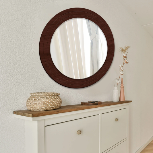 Round wooden-framed mirror on a wall above a white cabinet with wooden top.