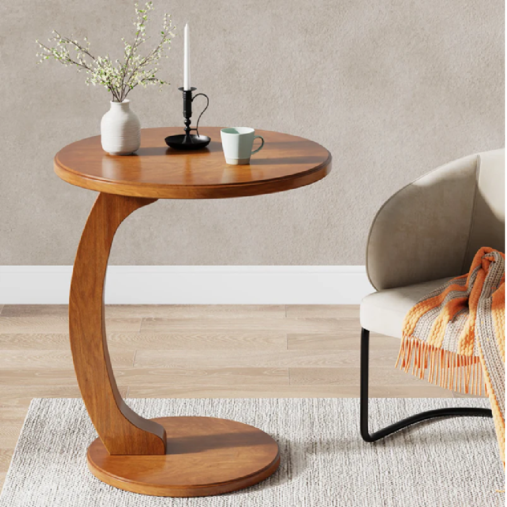 Wooden side table with decorative items next to a chair in a room.