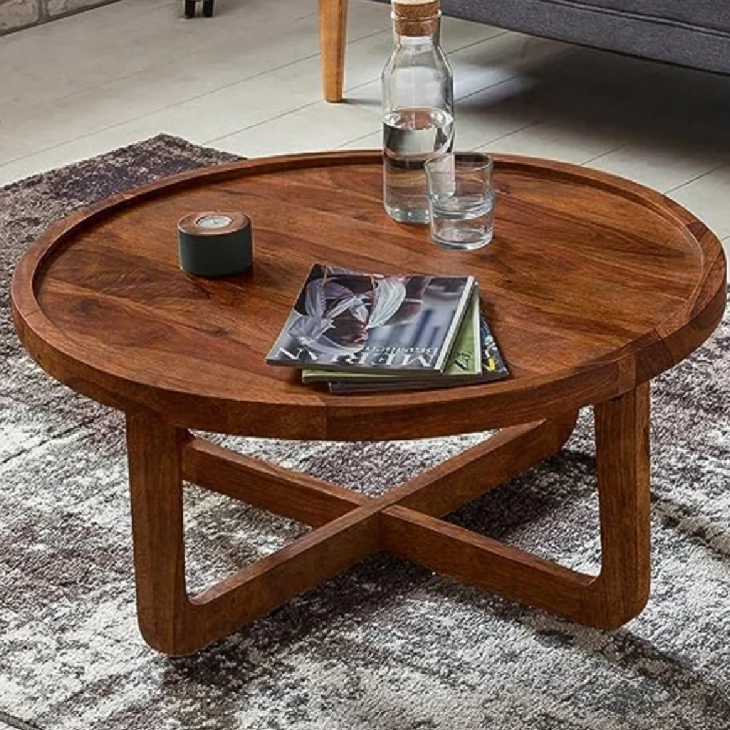 Wooden coffee table with a bottle, glass, and books on a rug