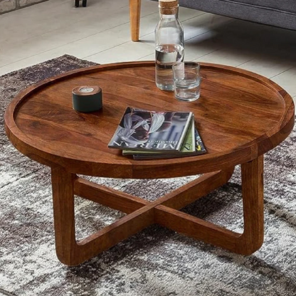 Wooden coffee table with a bottle, glass, and books on a rug