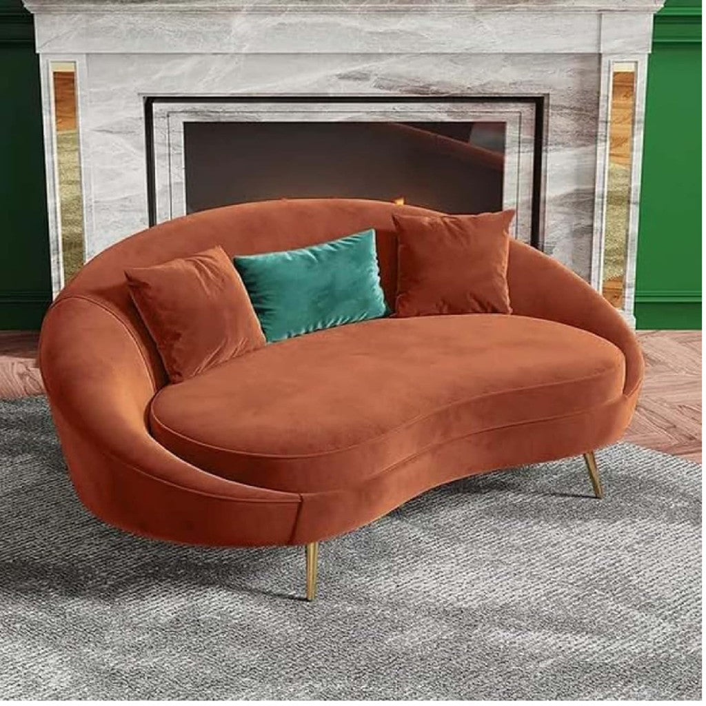Brown curved sofa with decorative pillows in a room with a fireplace.