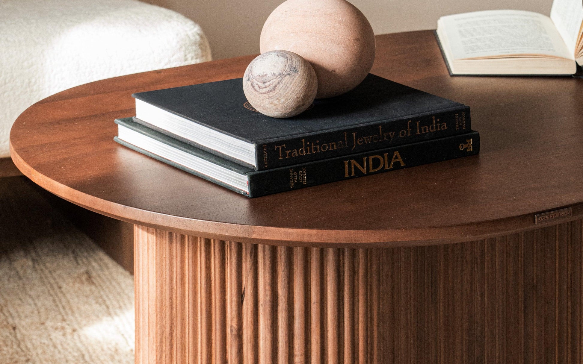 Wooden table with books and spherical objects on a neutral background