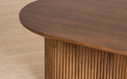 Close-up of a wooden table with a light wood floor background