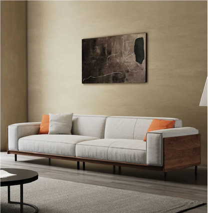 Modern living room with a gray sofa, wooden frame, and abstract painting on the wall.