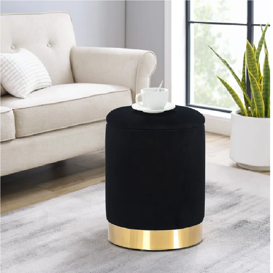 Black ottoman with gold base in a living room setting