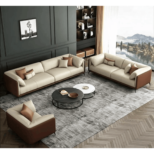 Modern living room with beige sectional sofa and armchair, round coffee table, and decorative elements.