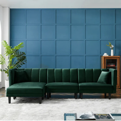 Green sectional sofa in a room with a blue paneled wall.