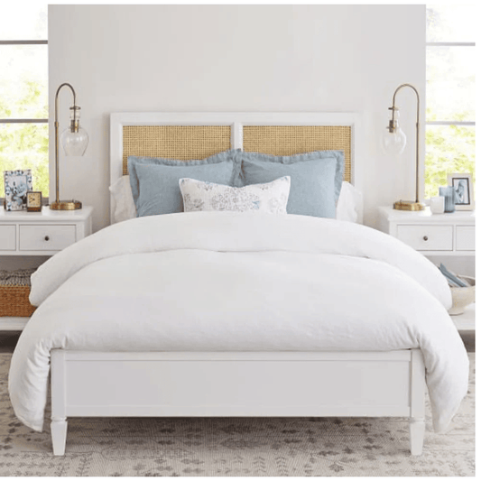 Bedroom with a white bed, light blue pillows, and gold headboard.