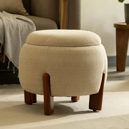 Beige ottoman with wooden legs in a living room setting