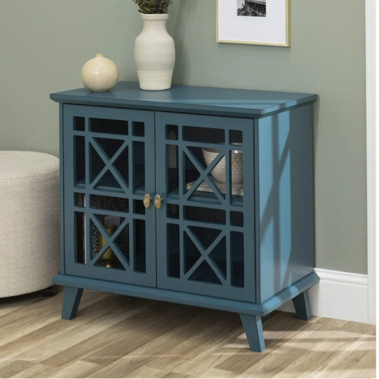 Blue cabinet with decorative items on a wooden floor against a green wall.