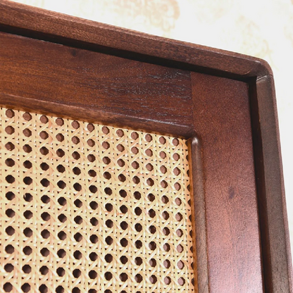 Close-up of a wooden frame with a woven cane seat