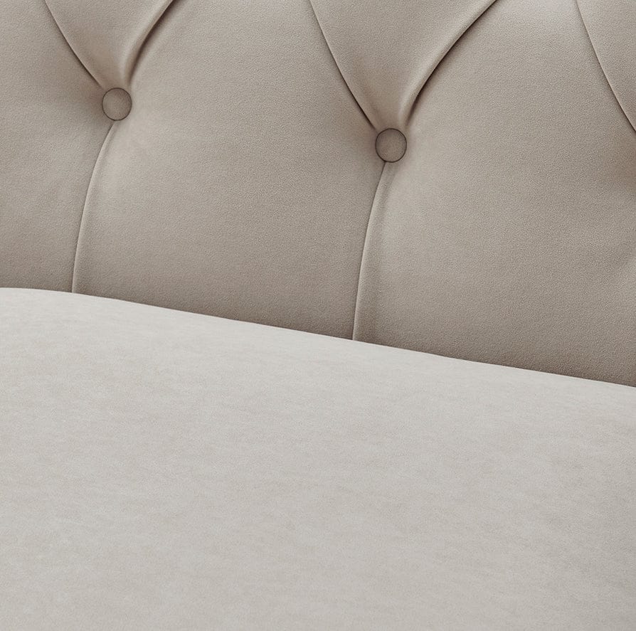 Close-up of a beige upholstered headboard with tufted design.