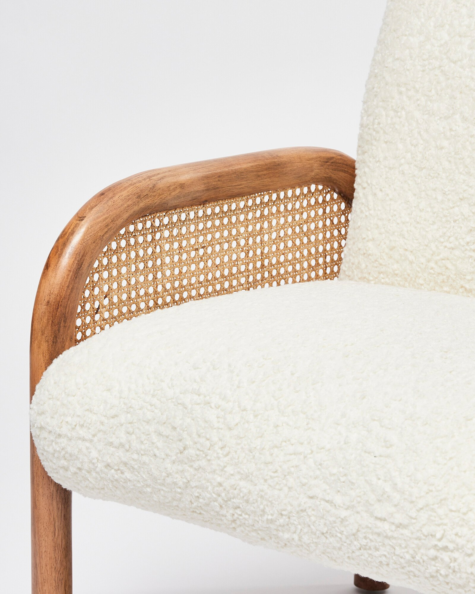 Chair with wooden frame and white cushion on a plain background