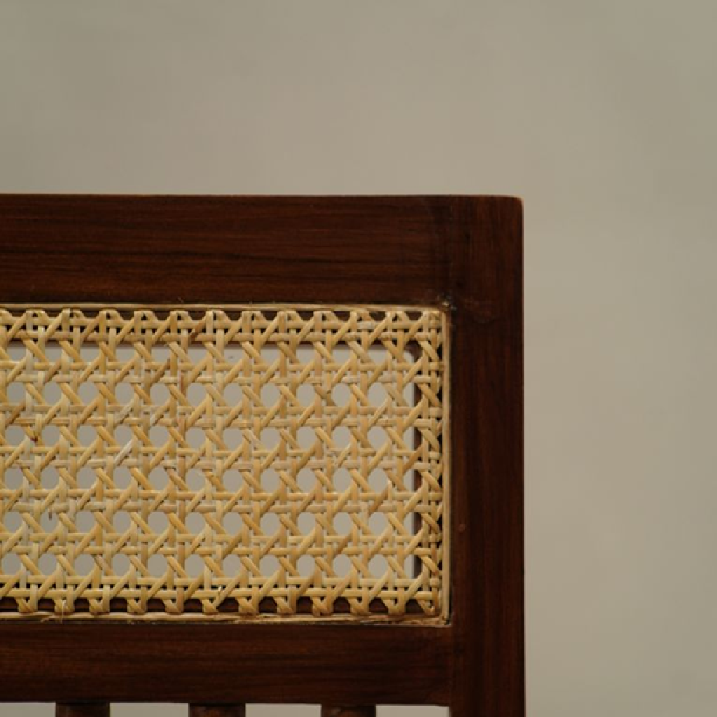 Wooden furniture with wicker backrest against a plain background