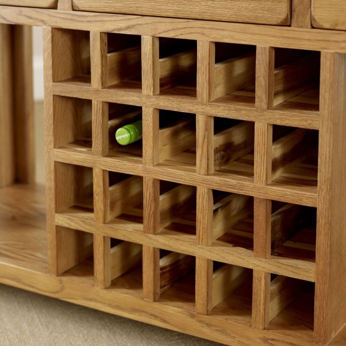 Wooden wine rack with a green bottle inside, on a neutral background