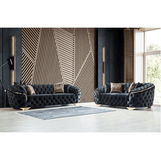 Two dark gray tufted sofas in a modern living room with geometric wall design.