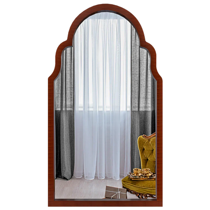 Wooden-framed mirror reflecting a room with curtains and a yellow chair.